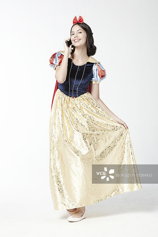 身穿白雪公主服装的女人使用智能手机图片素材