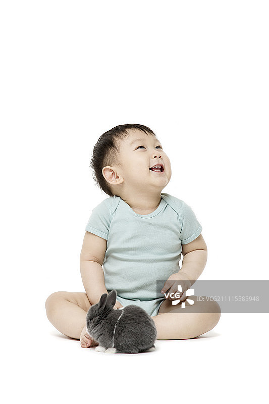 抱着兔子的微笑男婴图片素材