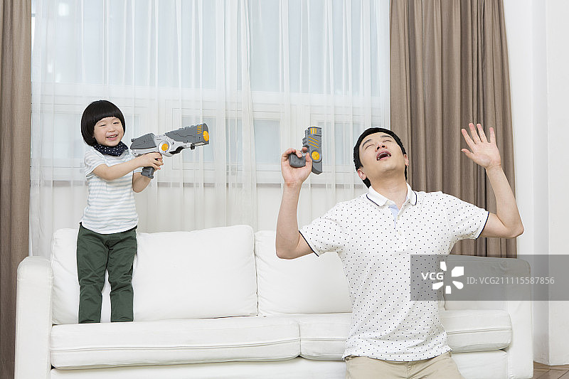 父子在客厅玩玩具枪图片素材