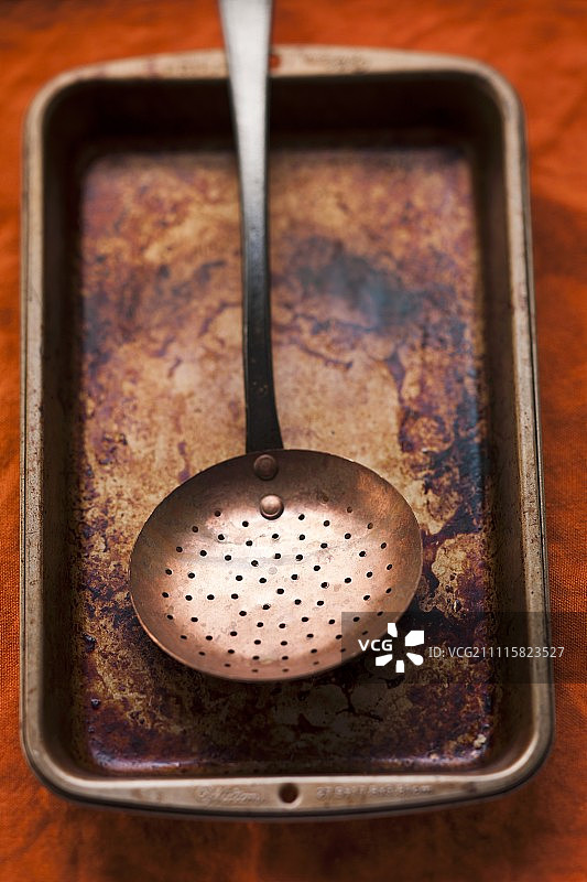 带有滤勺的烧焦的烤盘图片素材