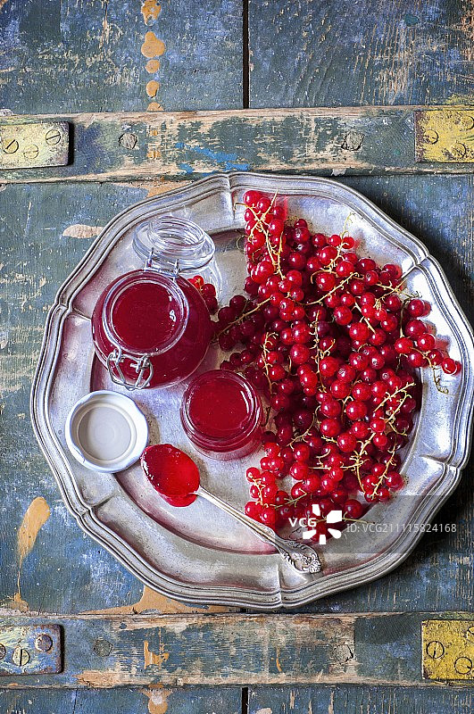 金属盘上玻璃罐装的红醋栗果酱图片素材