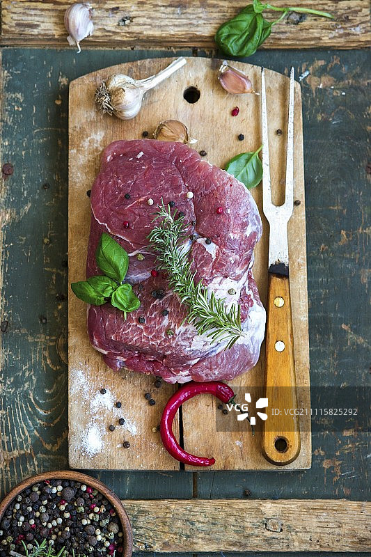 生猪肉配香草、蒜、辣椒，砧板上图片素材