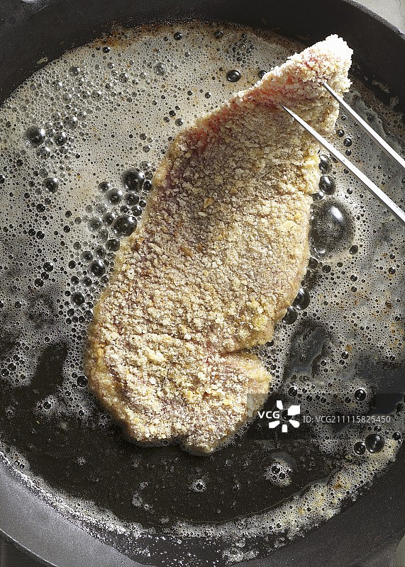 在平底锅中煎炸维也纳炸肉排图片素材