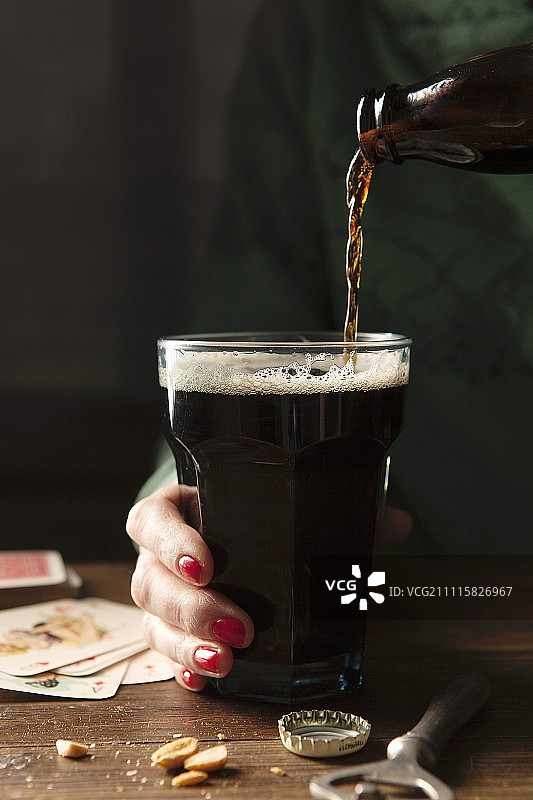 吉尼斯啤酒倒入大手持玻璃杯中图片素材