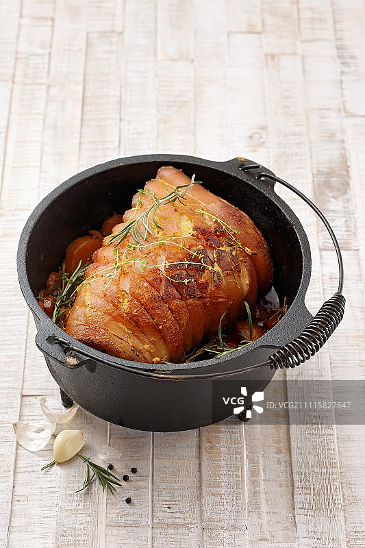 荷兰烤箱中的烤五花肉卷图片素材