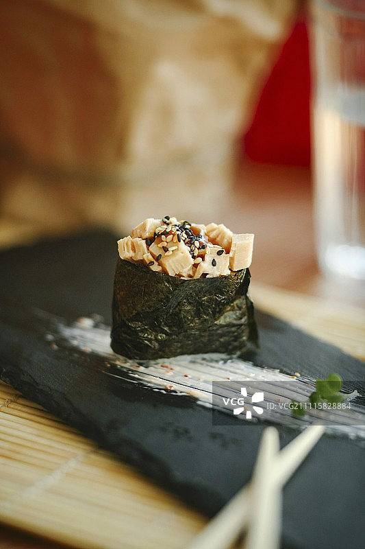 黑色盘子上带有切碎的煎蛋卷的寿司图片素材