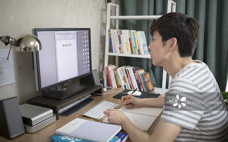 在桌前写简历的男人图片素材