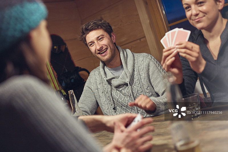 朋友们在小屋的桌子旁玩牌图片素材