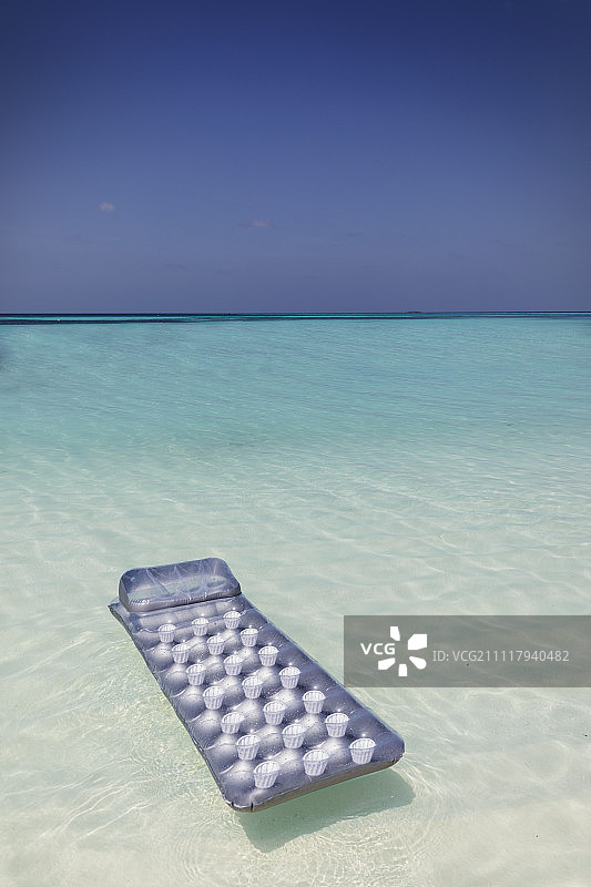 漂浮在宁静蓝色热带海洋上的充气筏图片素材