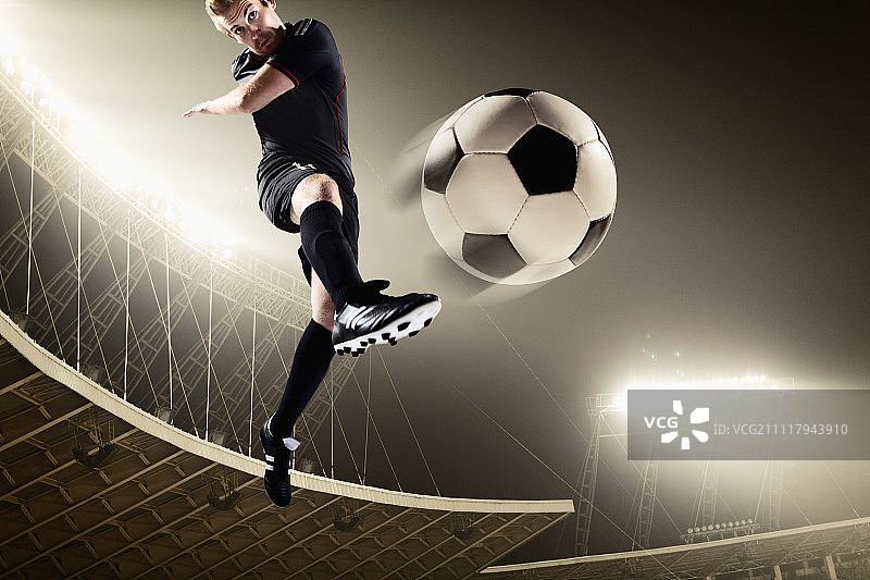 运动员在体育场踢足球图片素材