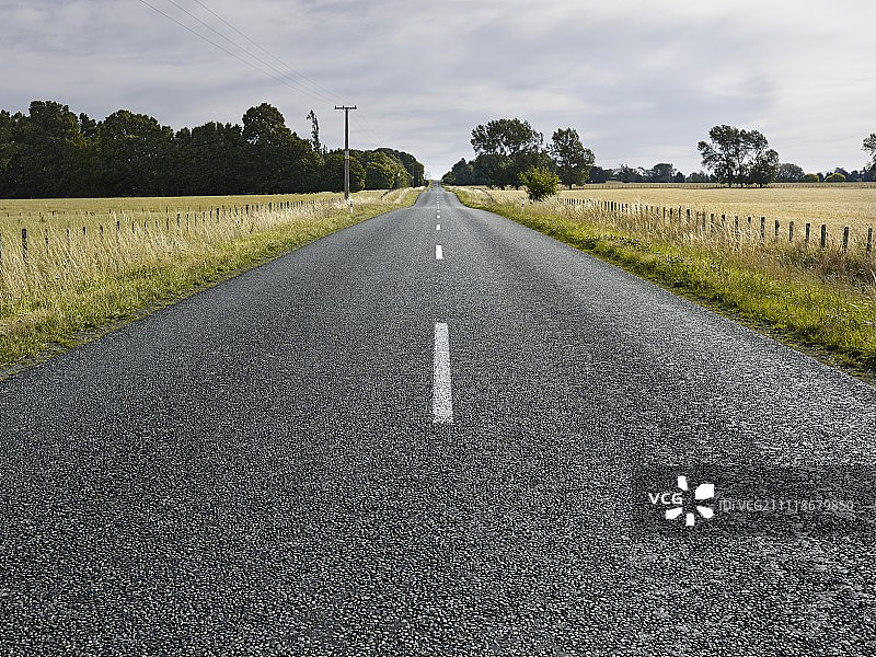 穿过草地的密封乡村公路中心线图片素材