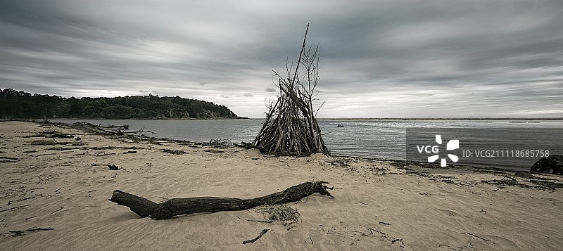 海滩上的浮木圆锥帐篷图片素材