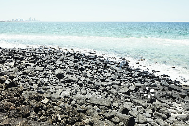 远处有城市的岩石海滩图片素材