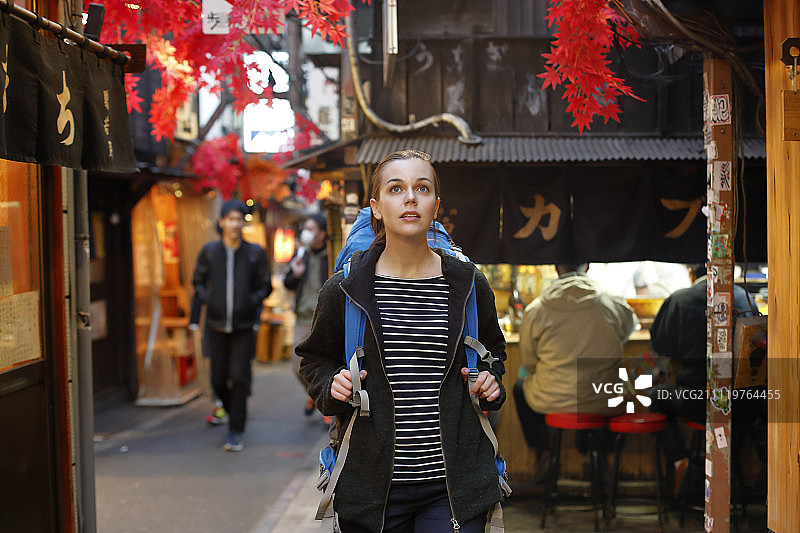 在东京市中心夜景下的白人背包客图片素材