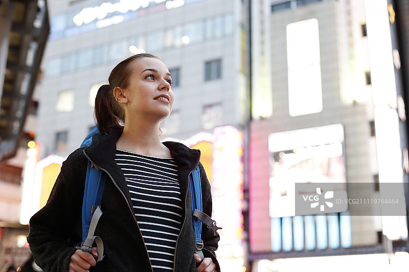 在东京市中心夜景下的白人背包客图片素材