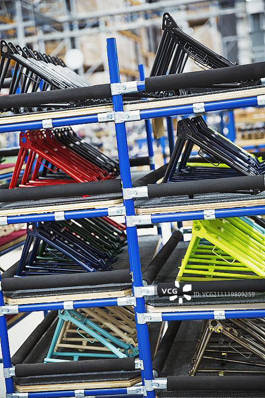 自行车工厂里放着彩色自行车车架的架子图片素材