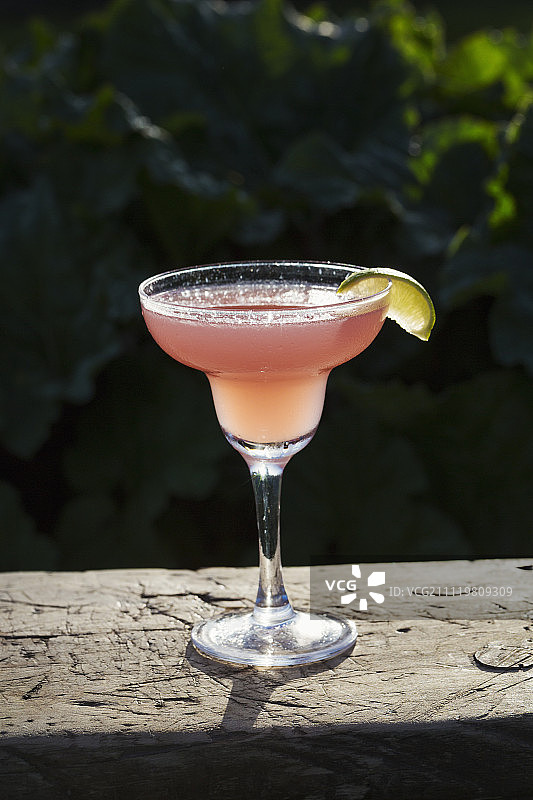 鸡尾酒杯中粉色饮品特写，饰以青柠片图片素材