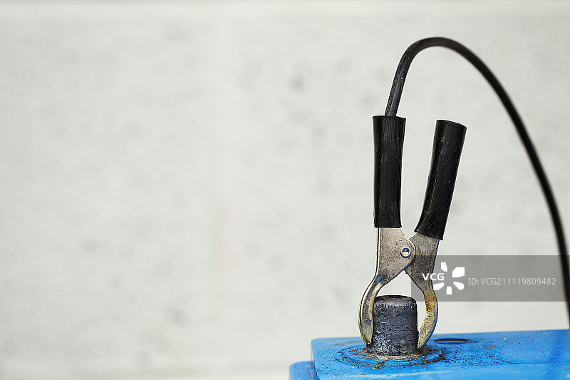 蓝色电池上的金属夹特写图片素材