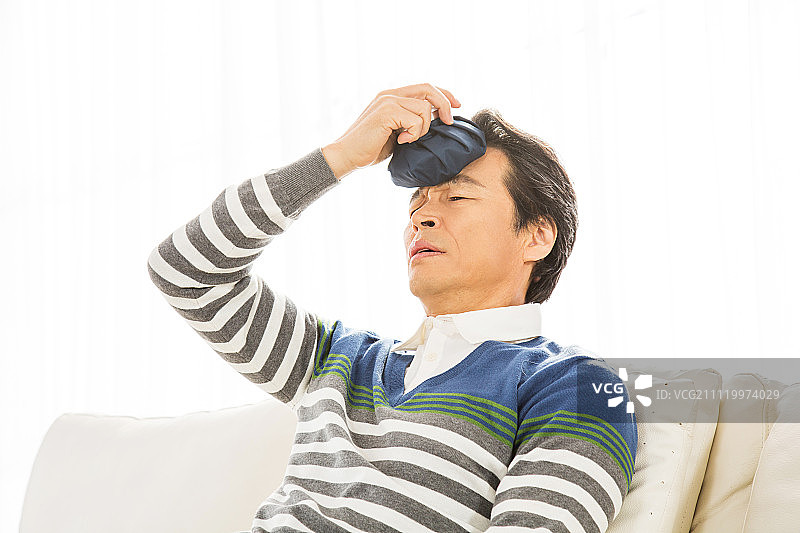 头部冰敷的中年男子图片素材