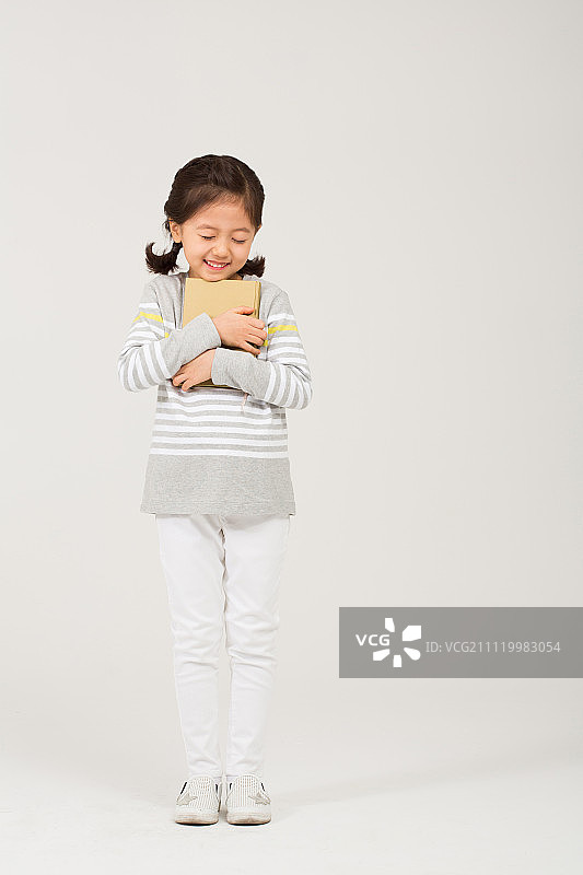 拿着儿童读物的女孩图片素材