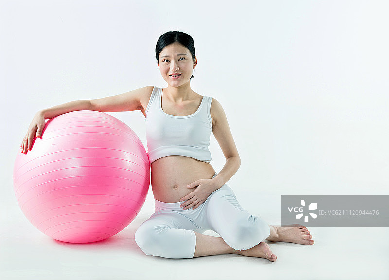 孕妇和健身球在白背景前图片素材