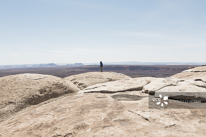 站在犹他州穆雷角的观景台上，远处是圣胡安峡谷和熊耳国家纪念碑的男人图片素材