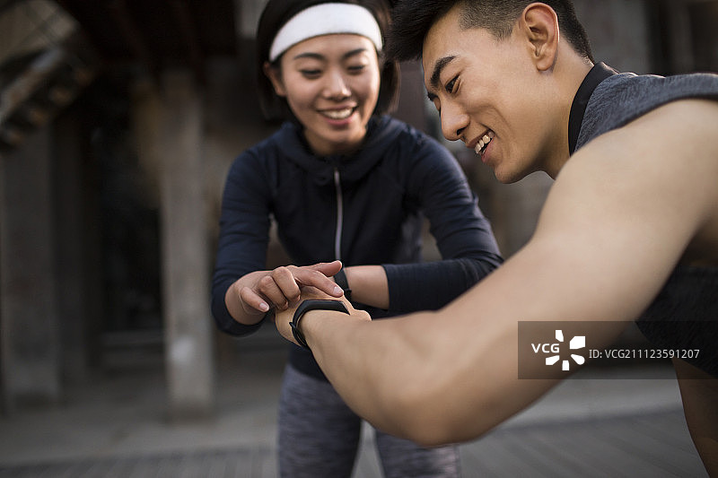 年轻情侣运动后查看智能手环图片素材