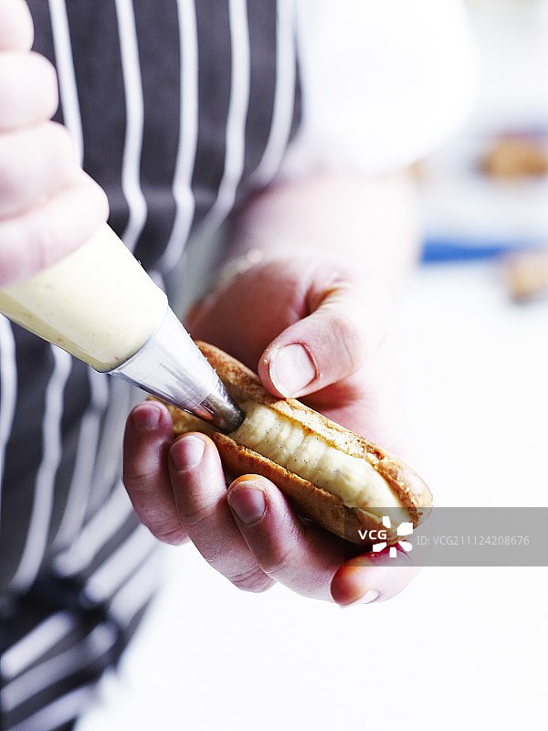用糕点奶油填充裱花袋并装饰闪电泡芙图片素材
