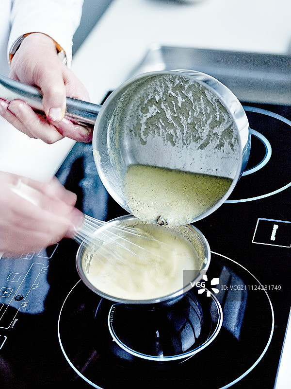 在制作过程中加入沸腾的牛奶并继续搅拌图片素材