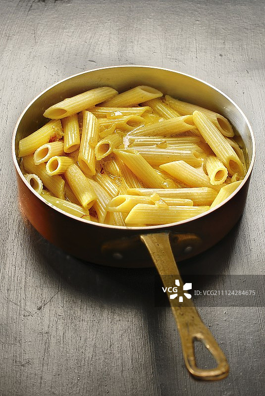 将煮熟的通心粉加入奶油洋葱藏红花酱中图片素材