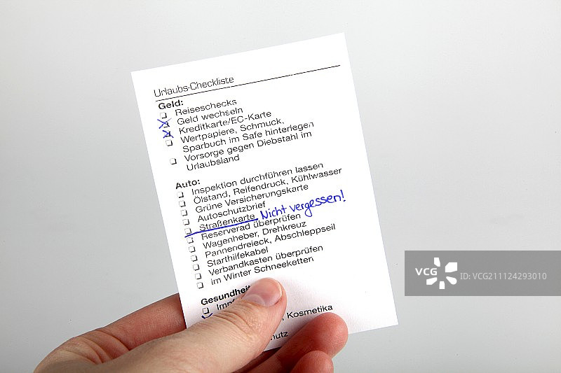 手部特写：拿着旅行清单，白色背景图片素材
