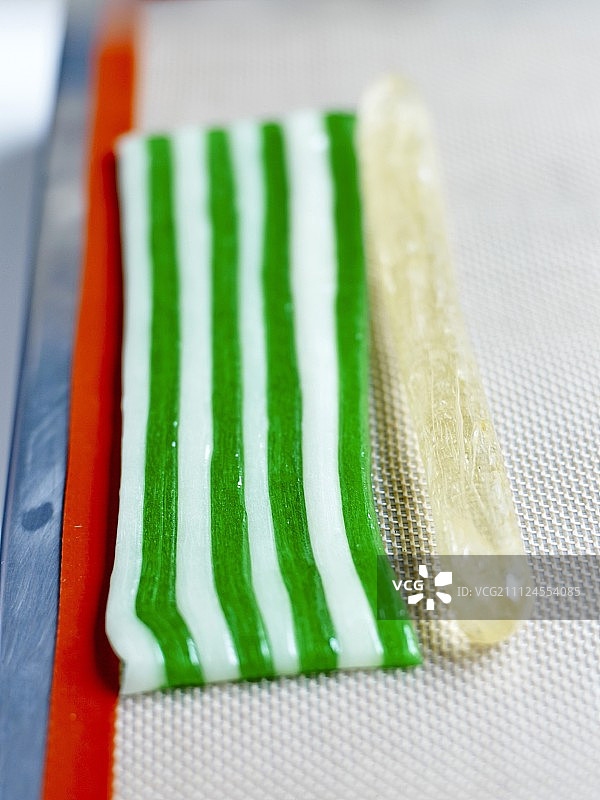 将半透明糖膏肠放在8条彩色糖膏旁边图片素材