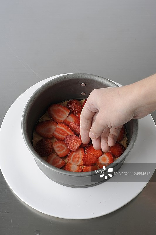 在海绵蛋糕上铺一层草莓片图片素材