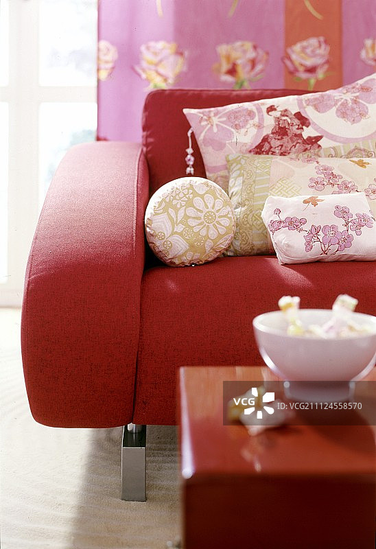 红色扶手椅上的亚洲风花卉图案枕头图片素材