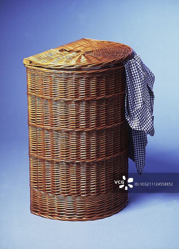 蓝色背景下的柳条洗衣篮图片素材