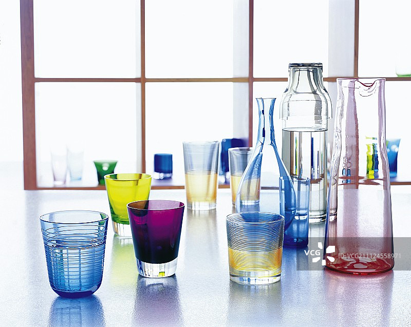 地板上的彩色玻璃杯、高脚杯和醒酒器图片素材