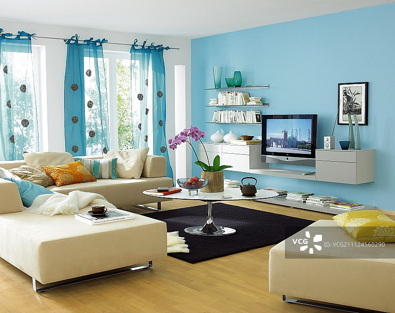 客厅内部：青绿色墙壁、沙发、靠垫、桌子和窗帘图片素材