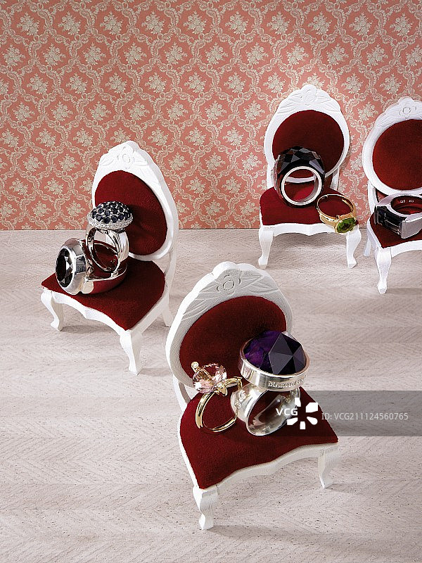 玩偶屋椅子上的银色和金色戒指图片素材