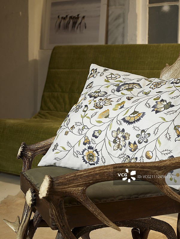 皮革扶手椅上带有花卉图案的枕头图片素材