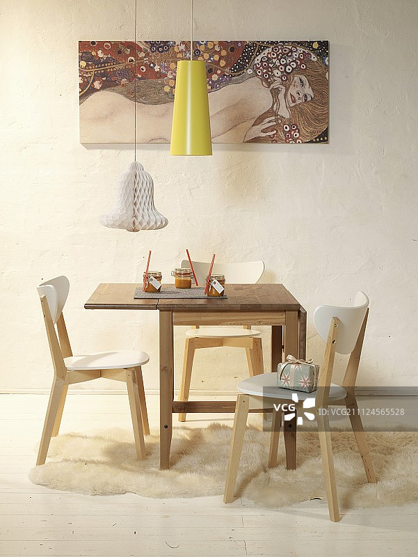配有折叠桌、椅子、落地灯和墙上挂画的用餐区图片素材