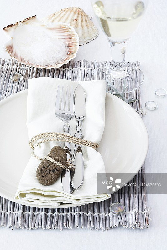 餐巾、叉子和刀子用石绳包裹在盘子上图片素材