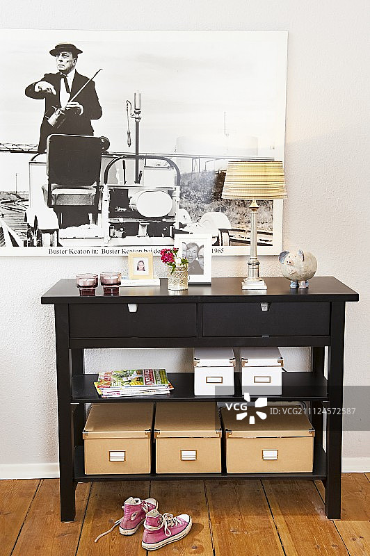 漆面餐具柜，带多个盒子和靠墙相框的灯图片素材