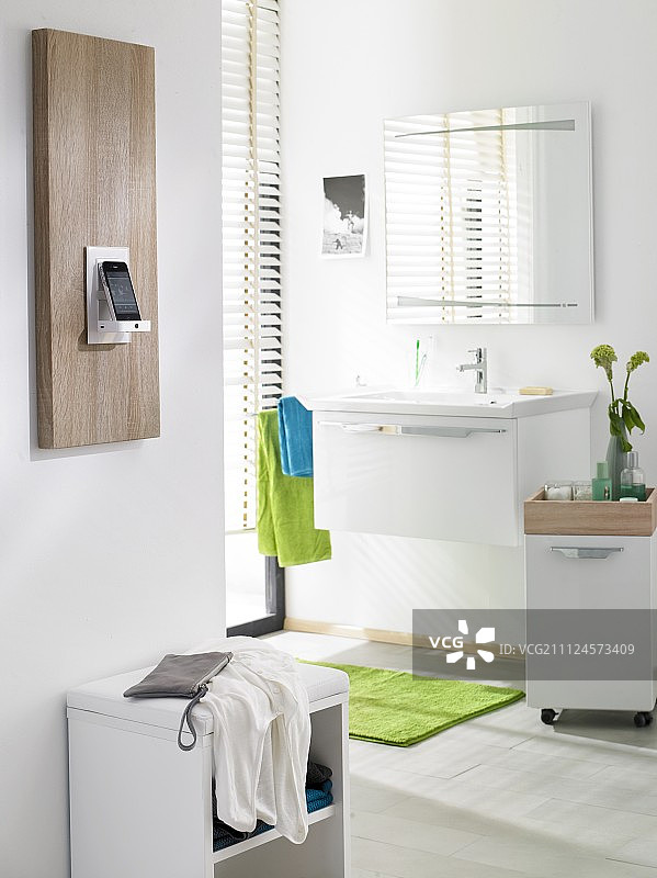 浴室木板上的手机和音箱底座图片素材