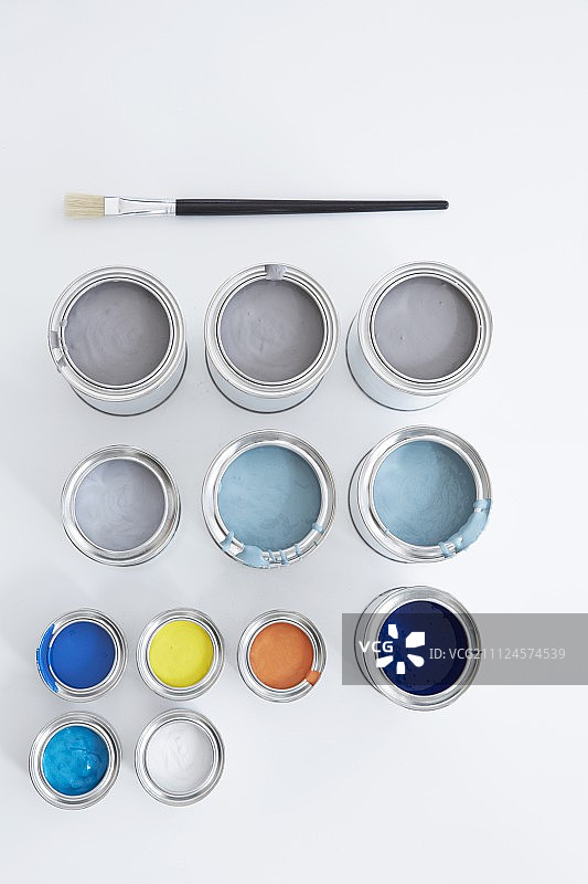 白色背景上的蓝色、灰色、黑色、白色和黄色颜料罐图片素材