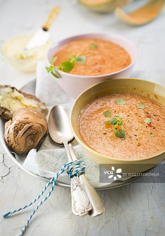 甜瓜汤、面包和黄油碗图片素材