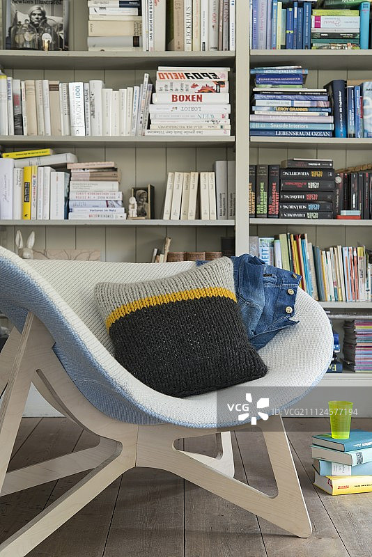 书架前的针织靠垫桶椅图片素材
