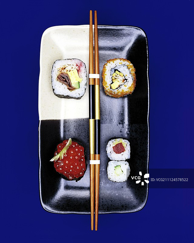 配有筷子的盘子上盛放的太卷、加州卷、寿司卷和军舰卷图片素材