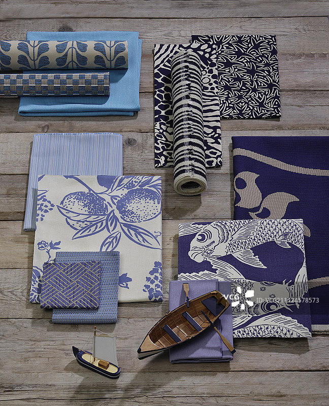 木质表面上各种图案的织物和小型木船图片素材