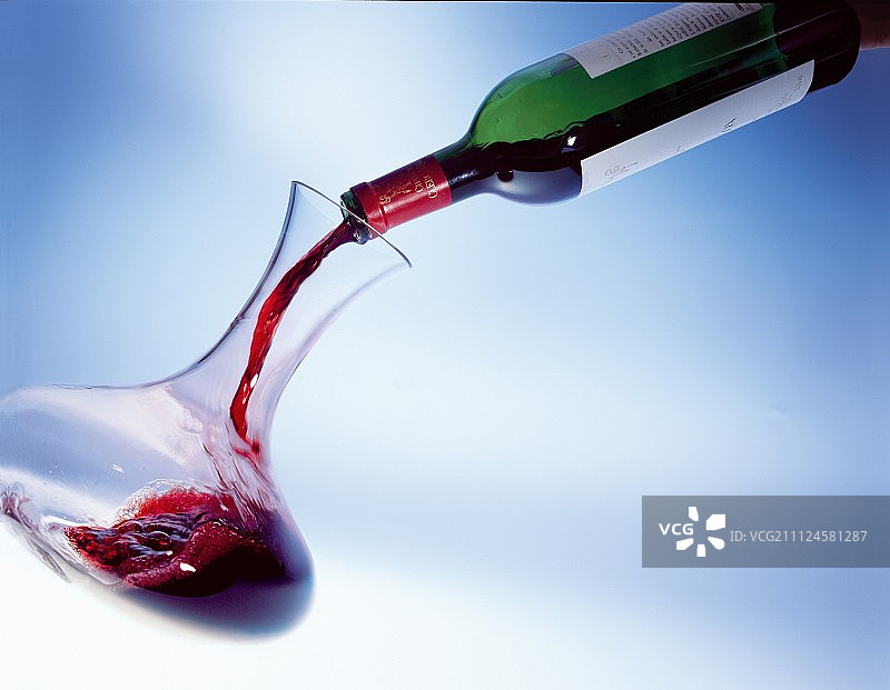 将红酒从瓶中倒入醒酒器图片素材