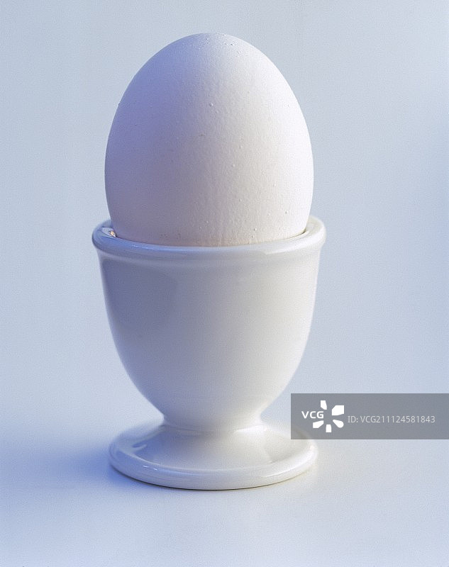 白色背景下的鸡蛋杯中的鸡蛋图片素材